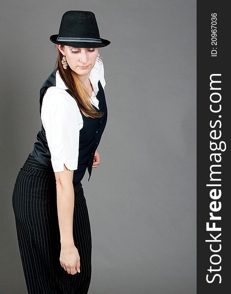 Caucasian female jazz dancer poses in front of a studio gray backdrop.