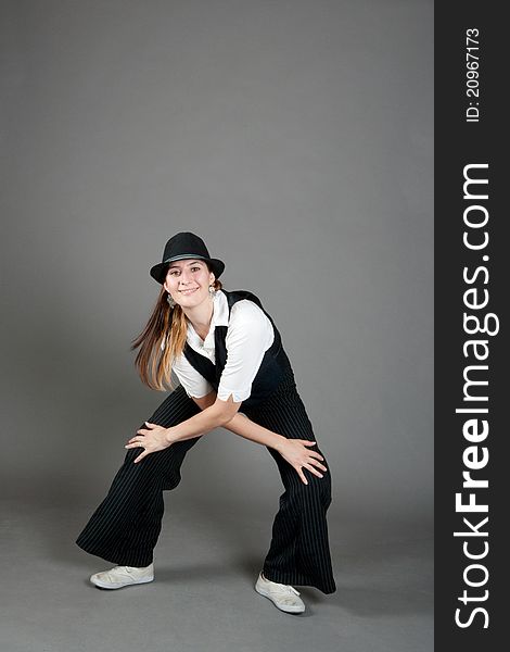 Caucasian female jazz dancer poses in front of a studio gray backdrop.