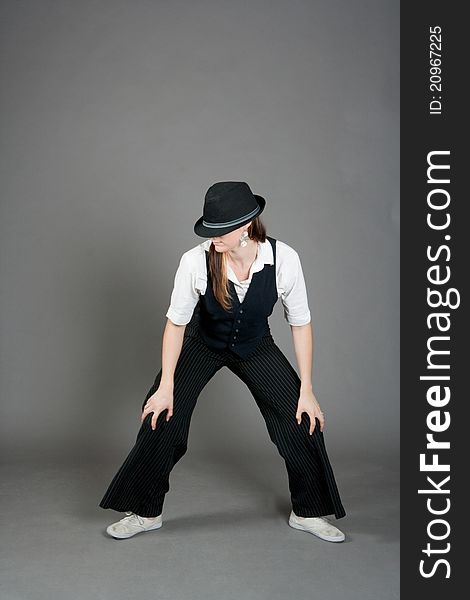 Caucasian female jazz dancer poses in front of a studio gray backdrop.