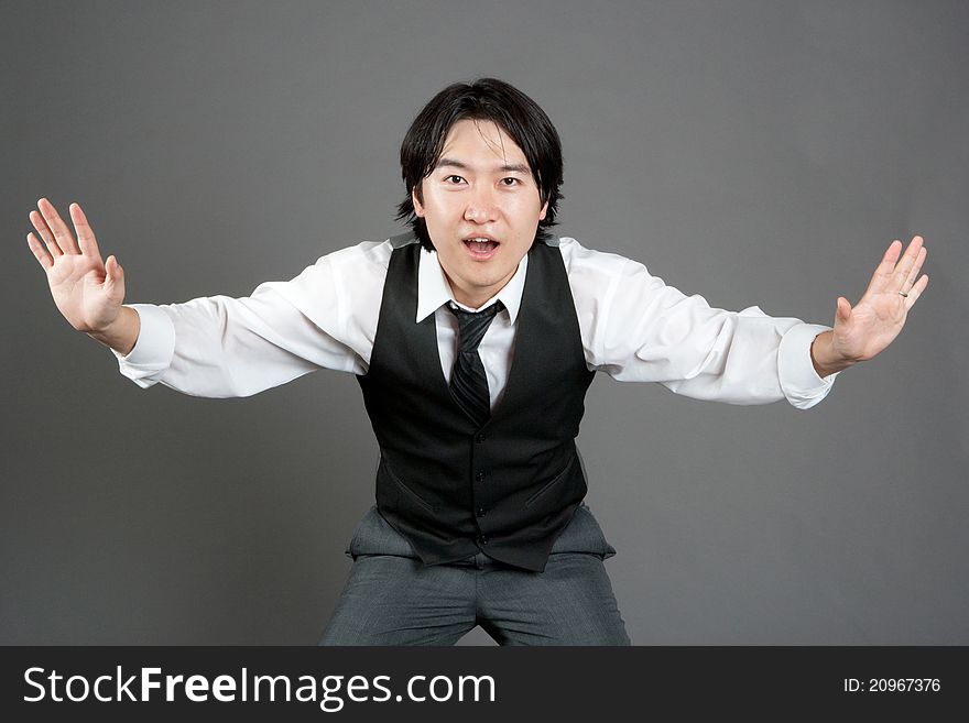 Asian male jazz dancer poses in front of studio gray backdrop.