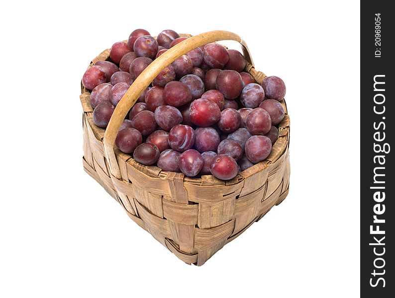 Wattled basket with ripe plums it is isolated on a white background. Wattled basket with ripe plums it is isolated on a white background.
