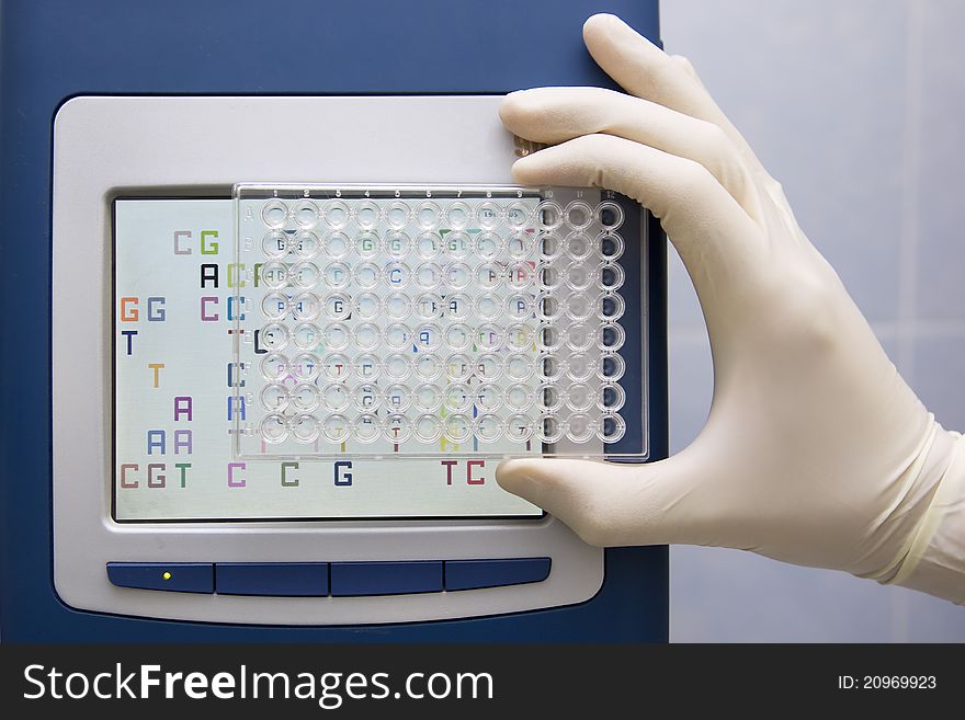 Well plate in front of screen of real-time pcr machine. Well plate in front of screen of real-time pcr machine