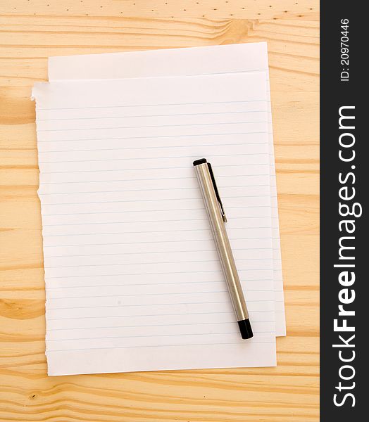 Paper with pen on wooden background. Paper with pen on wooden background