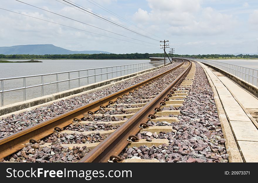 Railroad tracks curving across the lake