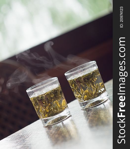 Glass of Chinese green tea on the table with steam at restaurant in Hangzhou, Xihu Lake, China