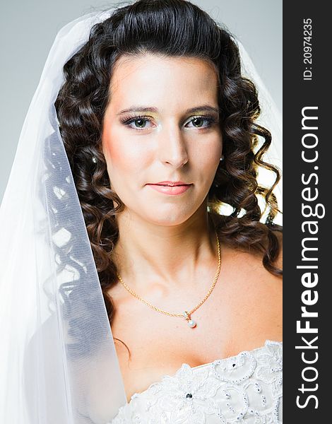 Studio close-up portrait of attractive bride with white veil. Studio close-up portrait of attractive bride with white veil