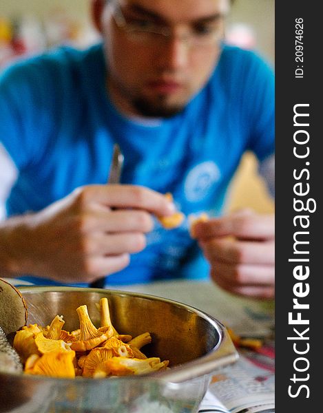 Young man cleaning cantarela mushrooms. Young man cleaning cantarela mushrooms