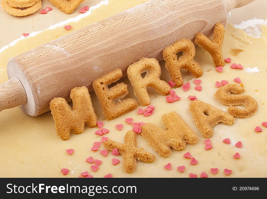 Studio-shot of preparing and baking cookies for christmas. baked letter biscuits spelling out the word merry xmas. Studio-shot of preparing and baking cookies for christmas. baked letter biscuits spelling out the word merry xmas.