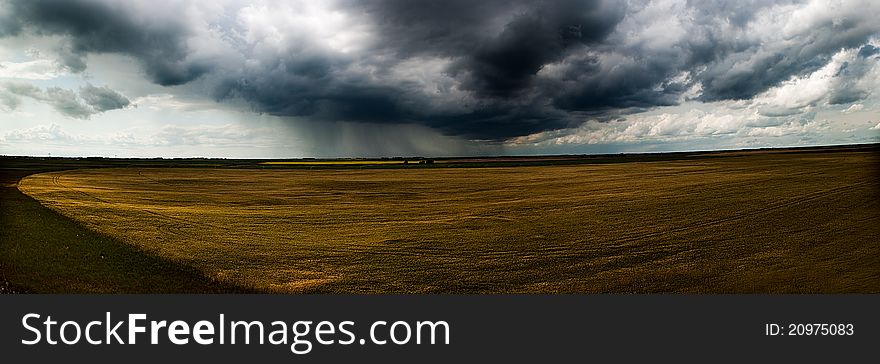 Field in alberta with storm coming