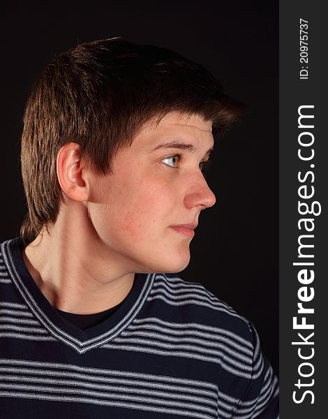 A young boy profile portrait on a black background. A young boy profile portrait on a black background