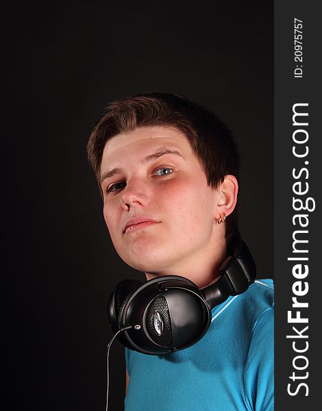 A young boy listening to music on the black background