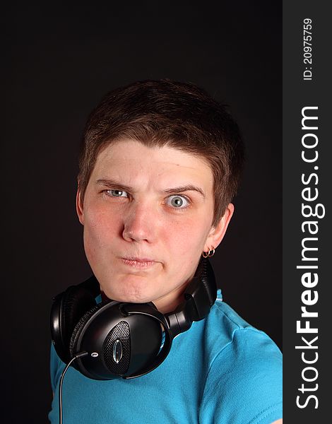 A young boy listening to music on the black background