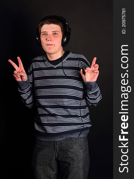 A young boy listening to music on the black background