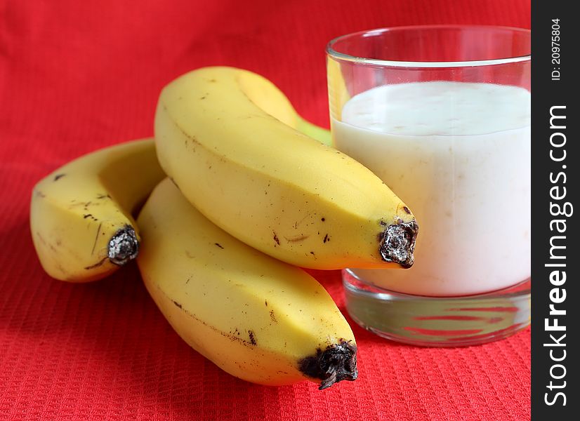 Banana smothie in a glass on the red background