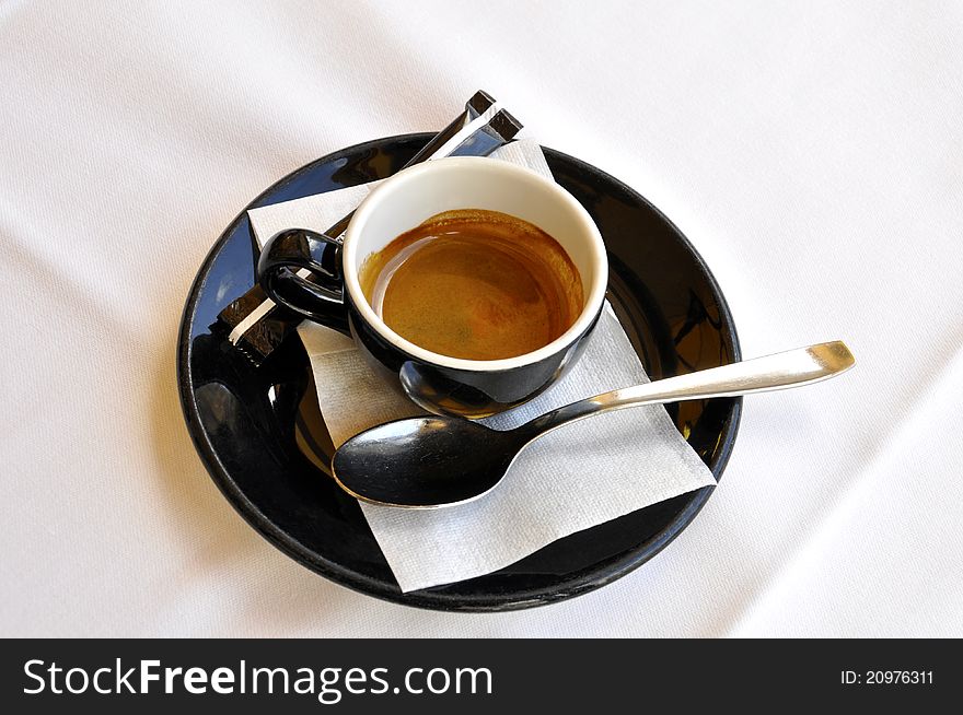 A cup of espresso on a white tablecloth. A cup of espresso on a white tablecloth