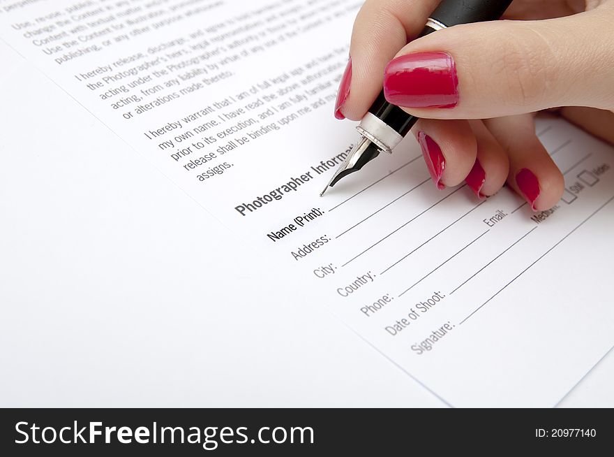 An image of Female hand signing contract