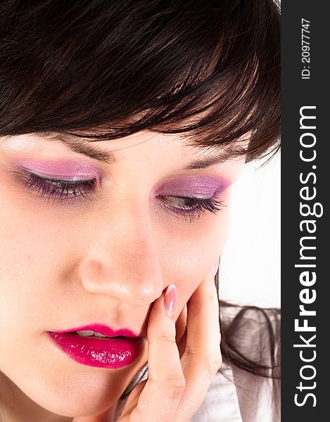 Young woman holding her face against white background