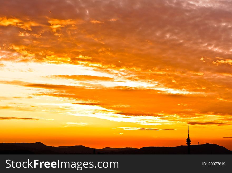 Silhouette of some mountains an da tower with orange sky. Silhouette of some mountains an da tower with orange sky