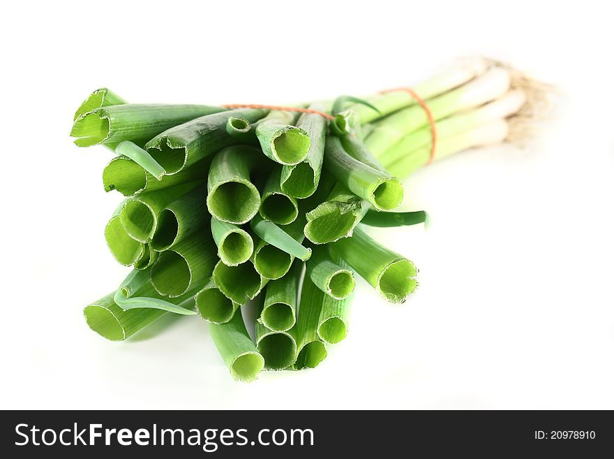 A bunch of spring onions on a white background