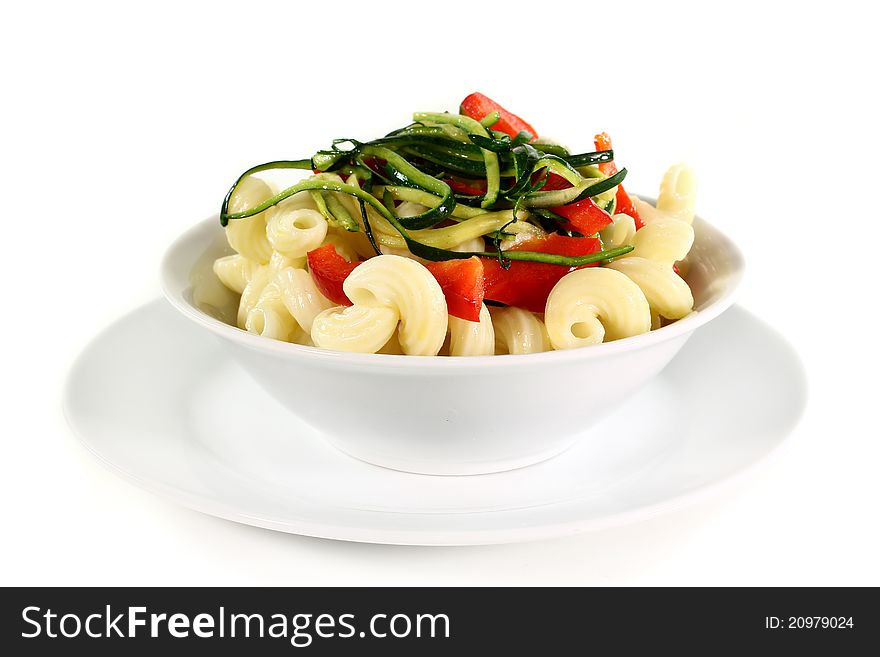 A white dish with a vegetarian pasta dish. A white dish with a vegetarian pasta dish