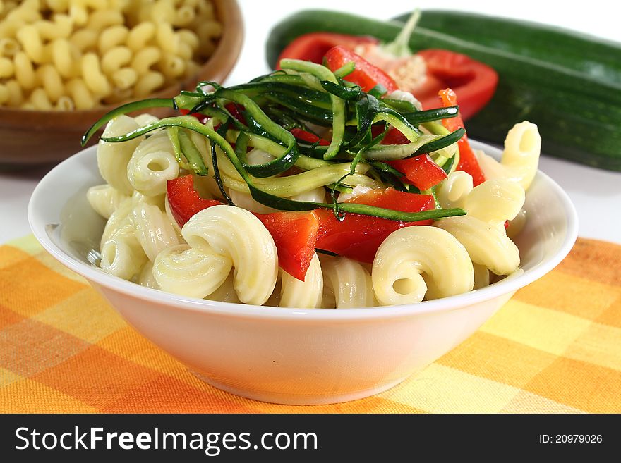 A white dish with a vegetarian pasta dish. A white dish with a vegetarian pasta dish