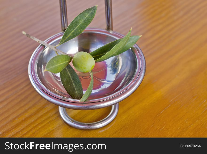 Olive branch with olives on a wooden background