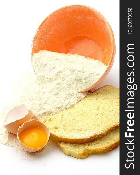 Bowl, flour, bread and eggs on a white background