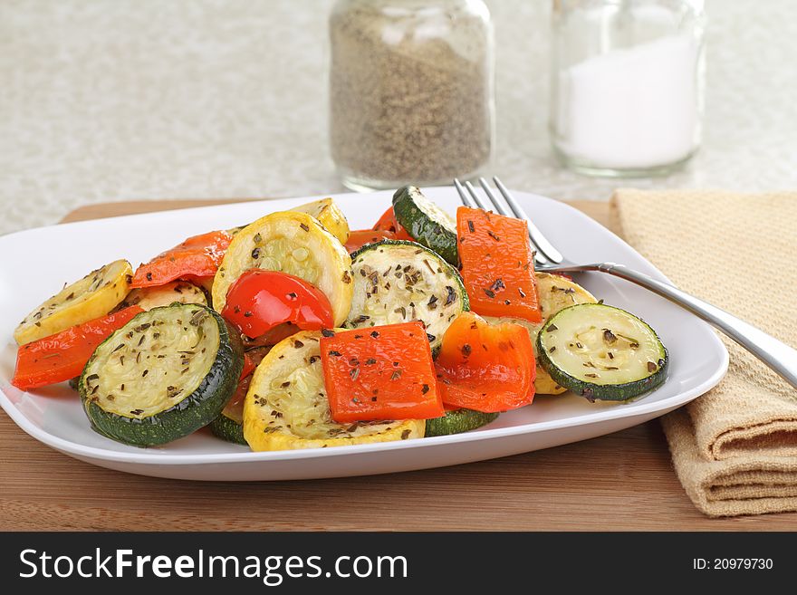 Baked summer squash and red peppers on a plate. Baked summer squash and red peppers on a plate