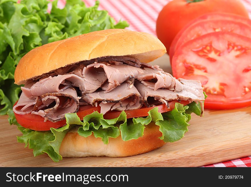 Closeup of a roast beef sandwich with lettuce and tomato