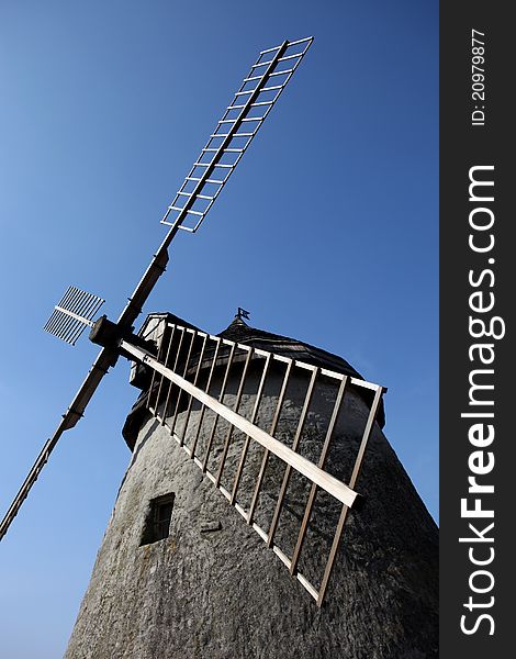 Photography of old wind mill with houses in the background