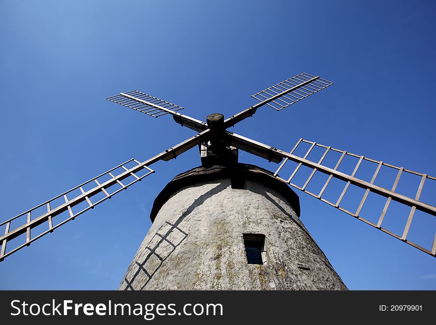 Photography of old wind mill with houses in the background