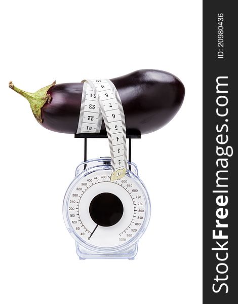 Eggplant with measuring tape on kitchen scale, isolated