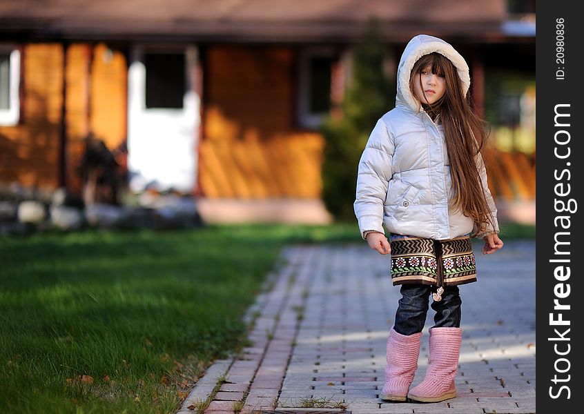 Full length outdoor portrait of adorable child girl with long dark hair in colorful warm clothe. Full length outdoor portrait of adorable child girl with long dark hair in colorful warm clothe