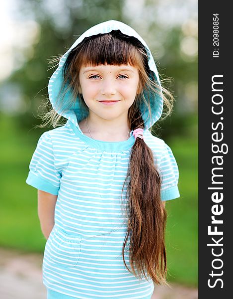 Full length outdoor portrait of adorable child girl in blue jacket with hood. Full length outdoor portrait of adorable child girl in blue jacket with hood