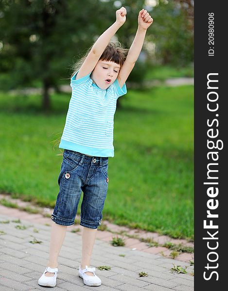 Portrait of a brunette child girl with hands up