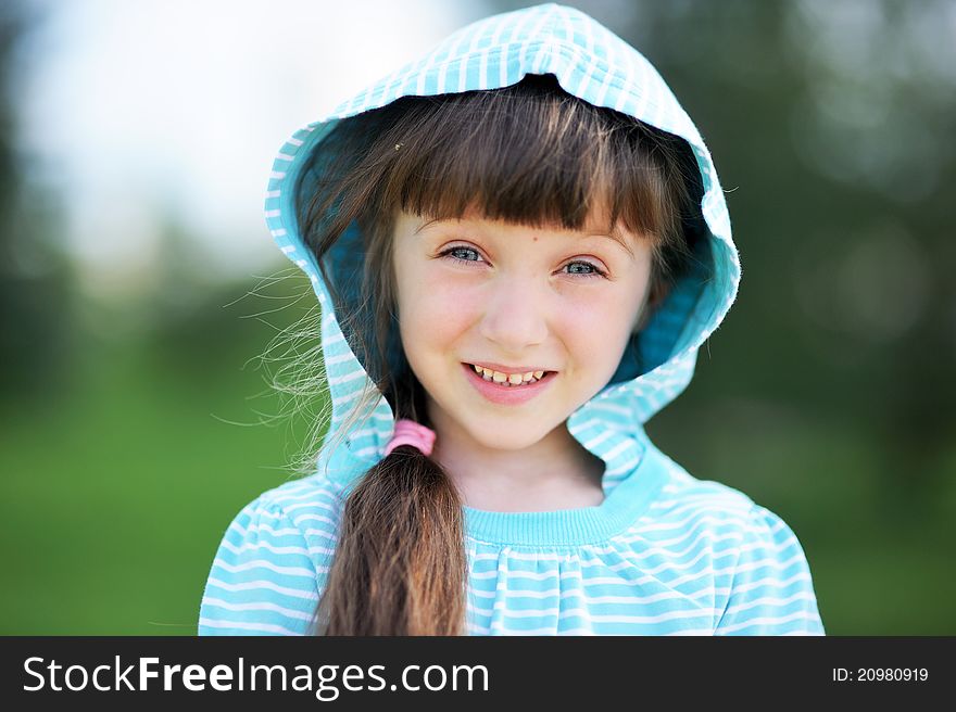 Outdoor portrait of adorable child girl in blue jacket with hood. Outdoor portrait of adorable child girl in blue jacket with hood