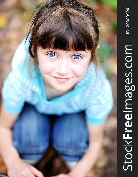 Outdoor portrait of cute child girl in blue jacket