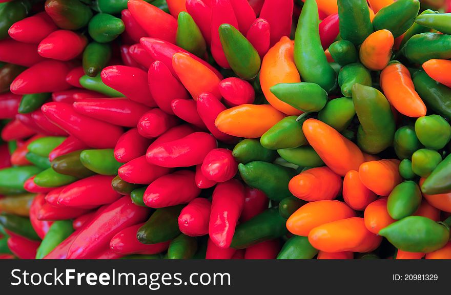 Bunch of bright colorful hot chili peppers closeup. Bunch of bright colorful hot chili peppers closeup