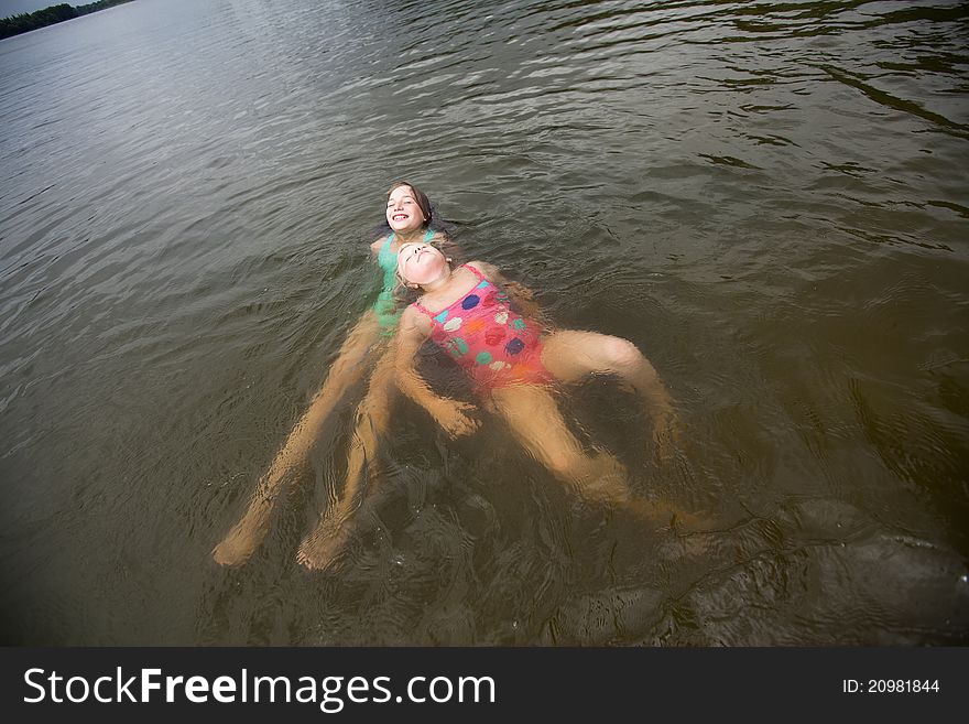 Two smilling girls swimming in lake,. Two smilling girls swimming in lake,