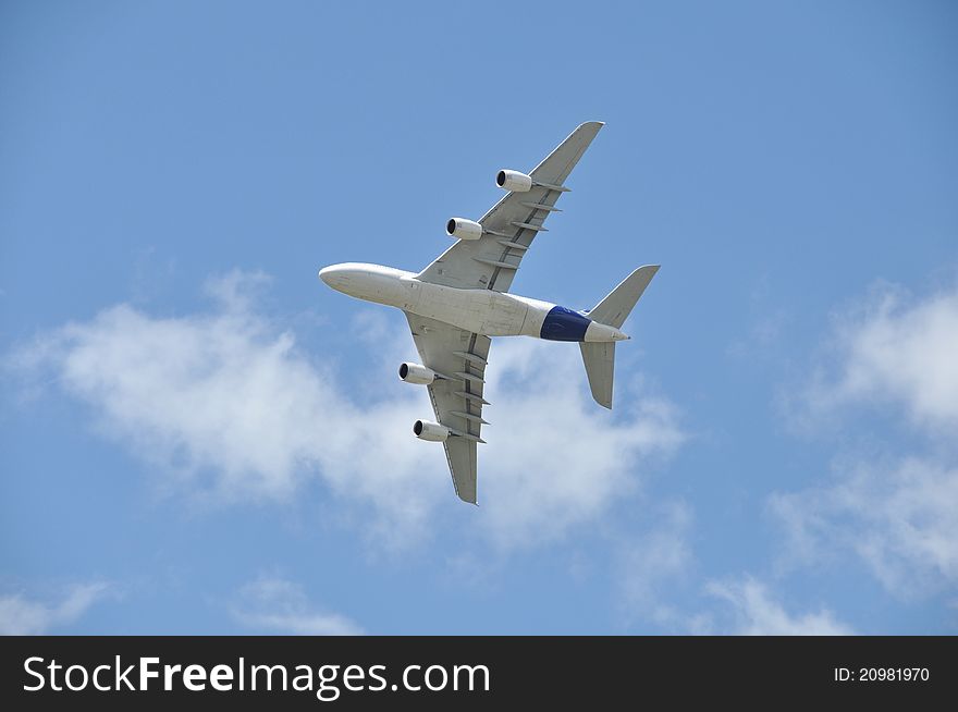 Flying airliner, white clouds and blue sky background