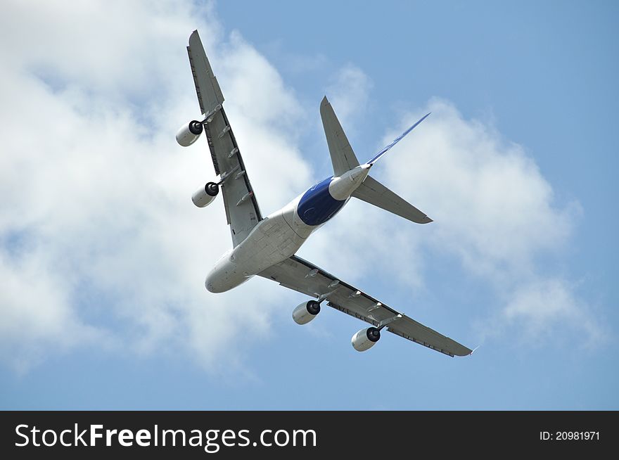 Flying airliner, blue sky and white clouds background