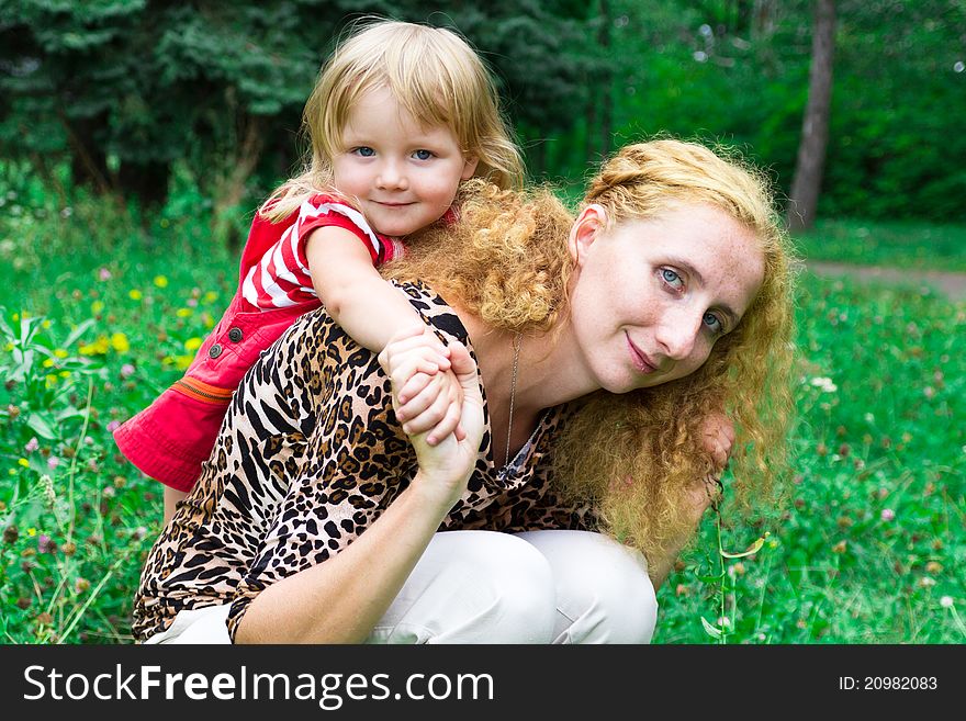 Beautiful girl with mother in the meadow outdoor