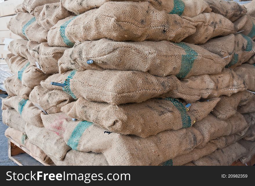 Brown sacks stack on wooden pallet in stockpile tilted. Brown sacks stack on wooden pallet in stockpile tilted