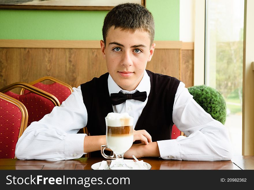 A teenager boy enjoying coffee in a cafe