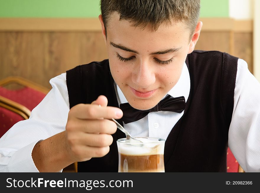 A Teenager Boy Enjoying Coffee In A Cafe