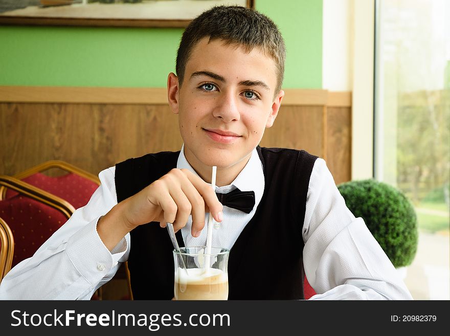 A teenager boy enjoying coffee in a cafe