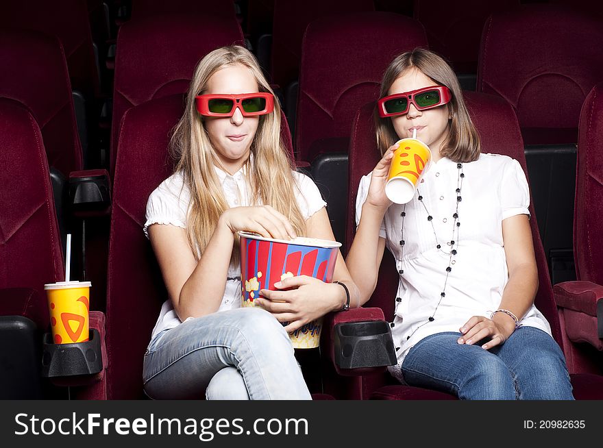 Two Beautiful Girls Watching A Movie At The Cinema