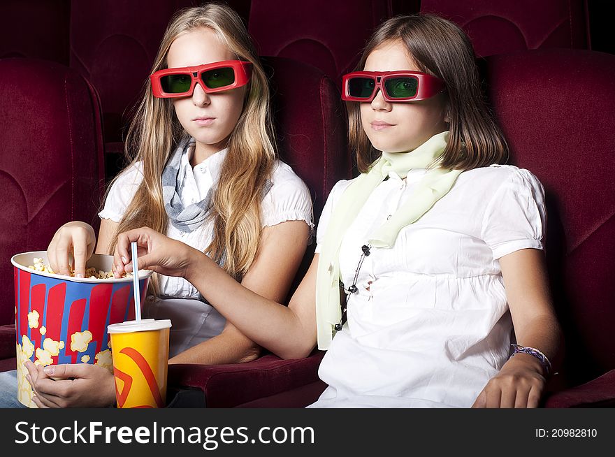 Two Beautiful Girls Watching A Movie At The Cinema