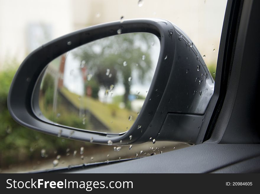 A rear mirror on a rainy day.