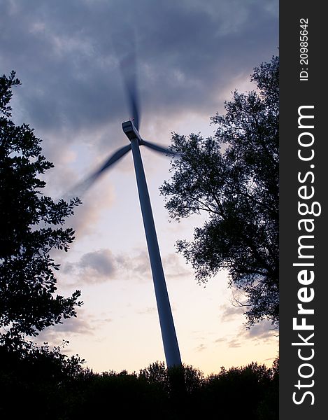 An image of wind turbine at the sunset